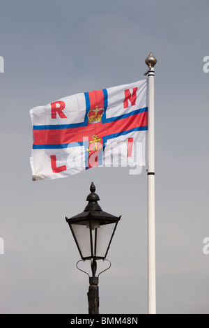 Großbritannien, England, Devon, Brixham Hafen, RNLI-Flagge über alte altmodische Kai Straßenlaterne Stockfoto