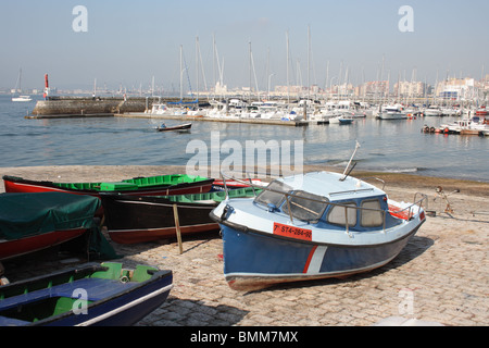 Angelboote/Fischerboote auf der Helling der Stein Hafen von Santander mit Hafen und Stadt im Hintergrund, Santander, Kantabrien, Spanien Stockfoto