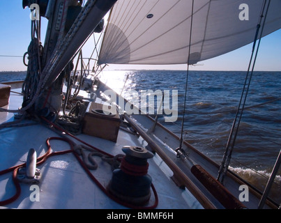 Sonne, Einstellung Szene hinter die Segel an Bord das Deck des zwei-Mast-Segelschiff mit Details der Takelage, Masten und Segeln Teile Stockfoto