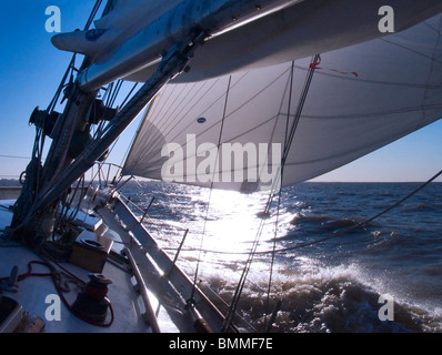 Sonne, Einstellung Szene hinter die Segel an Bord das Deck des zwei-Mast-Segelschiff mit Details der Takelage, Masten und Segeln Teile Stockfoto