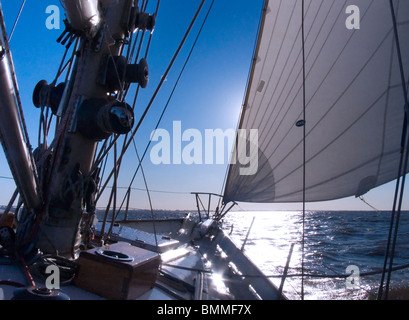 Sonne, Einstellung Szene hinter die Segel an Bord das Deck des zwei-Mast-Segelschiff mit Details der Takelage, Masten und Segeln Teile Stockfoto