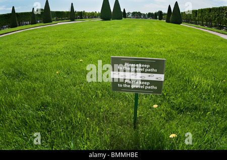 Bitte, halten Sie nicht Kiesweg. -Tag mit Hinweis auf dem grünen Rasen in Peterhof, St. Petersburg, Russland. Text auf Russisch und Englisch Stockfoto
