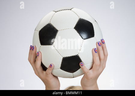 Hand mit britischer Flagge gemalt auf die Fingernägel mit einem Fußball Stockfoto