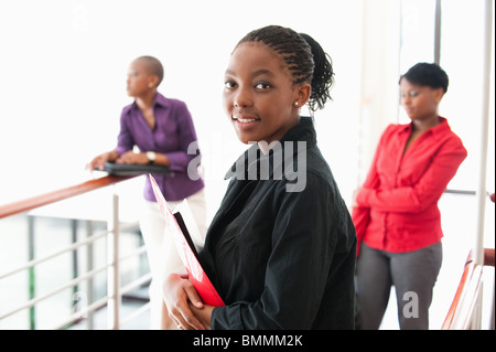 Porträt der jungen Unternehmerin mit zwei Frauen im Hintergrund, Johannesburg, Provinz Gauteng, Südafrika Stockfoto