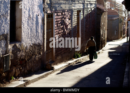 Eine Frau geht auf eine sonnige Straße in Potosí in Bolivien Stockfoto