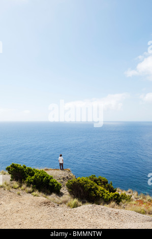 Mann am Rand einer Klippe auf der Suche auf See in Insel Faial, Azoren, Portugal Stockfoto