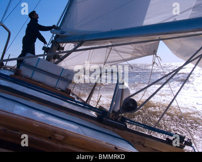 Sonne, Einstellung Szene hinter die Segel an Bord das Deck des zwei-Mast-Segelschiff mit Details der Takelage, Masten und Segeln Teile Stockfoto