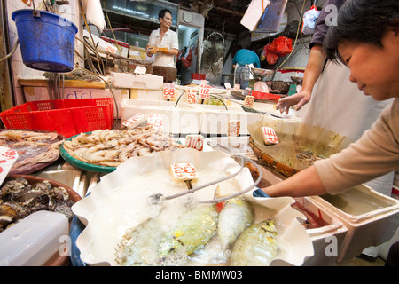 Fische und Meeresfrüchte auf dem Display im Shop im Fischmarkt in Hong Kong Stockfoto