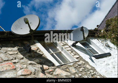 Fernsehen Satellitenschüsseln an Außenwand der Cottages in Llanwrtyd Wells Powys Mid Wales UK Stockfoto