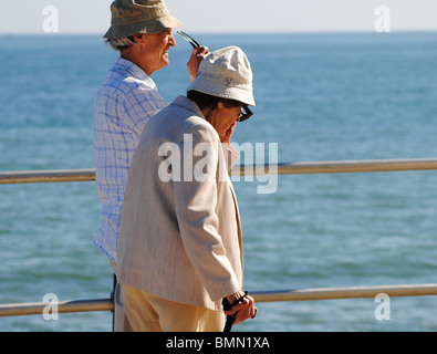 Ein älteres Ehepaar Fuß entlang der Strandpromenade in Charmouth, Jurassic Coast, Dorset, England Stockfoto