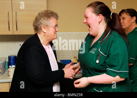 Mitarbeiter Interaktion mit älteren Bewohner in einem Altenheim, Wirral, UK Stockfoto