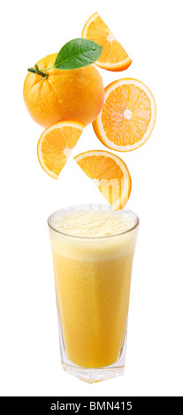 Scheiben von Orange fallen in ein Glas frischen Orangensaft Stockfoto