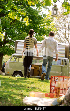 Ein junges Paar genießt einen Campingurlaub in einem klassischen VW-Wohnmobil. Stockfoto