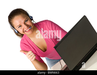 schönes lächelndes Mädchen sitzt mit Notebook in den Kopfhörern und Gestikulieren ok, isoliert auf weiss Stockfoto