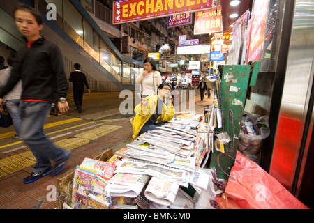 Man verkaufte Zeitungen und Magazine auch telefonieren mit Handy in Hongkong Stockfoto