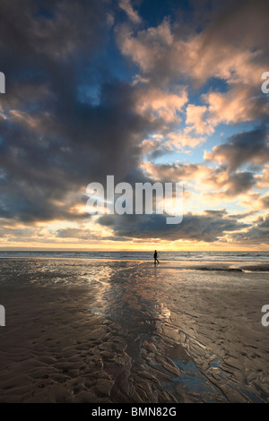 Ein einsamer Waker Silhouette unter einem dramatischen Winterhimmel über Dunraven Bay in Südliches Wales Stockfoto