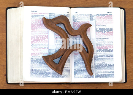 Christliche Ausgabe der Bibel in roter Schrift mit der Form des Heiligen Geistes über ein Kapitel von Lukas im Neuen Testament. Geist des Herrn in der offenen Bibel Stockfoto