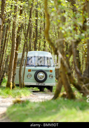 Ein junges Paar genießt einen Campingurlaub in einem klassischen VW-Wohnmobil. Stockfoto