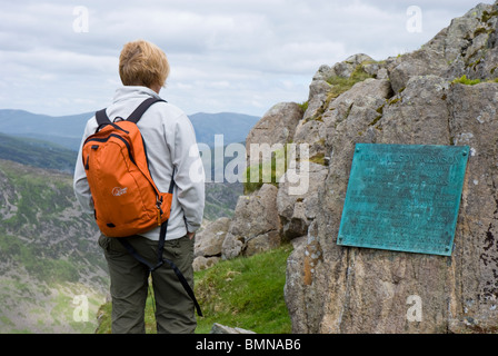 Eine weibliche Walker lesen die Plakette auf Robinsons Cairn, Säule. Stockfoto