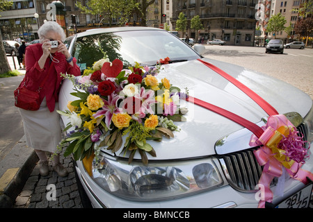 Eine alte Dame fotografieren Hochzeitsauto mit einem Blumenstrauß in Paris Stockfoto