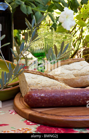 Eine Tabelle in einem Garten set mit Wein Brot und salami Stockfoto