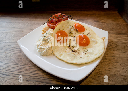 Drei Wachteln Eiern Sonnenseite mit Tomate zum Frühstück gebraten. Stockfoto