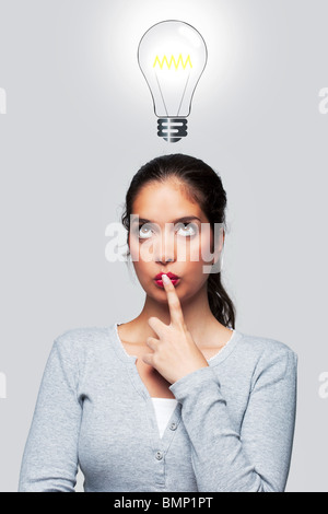 Konzept-Bild einer Frau mit eine glänzende Idee, Illustration einer Glühbirne über dem Kopf. Stockfoto