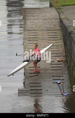 Eine Mädchen kämpft um ein einzelner Scull Ruderboot aus dem Fluss in Limerick City heben Rep of Ireland. Stockfoto