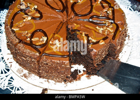 Stück dunkle Schokolade Schicht Kuchen Karamell Pecan Vereisung rasiert Schokolade Stockfoto