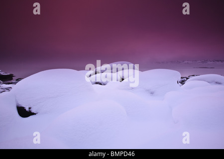 Eis, Schnee, Nebel und farbenfrohen Meer bei Sonnenuntergang am Oslofjord an Larkollen in Rygge Kommune, Østfold fylke, Norwegen.