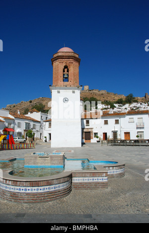 Glockenturm und Brunnen auf dem Marktplatz mit dem Schloss auf der Rückseite, Jimena De La Frontera, Provinz Cadiz, Andalusien, Spanien. Stockfoto