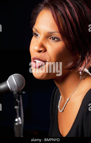 Frau ins Mikrofon singen Stockfoto