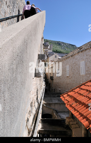 Touristen, die die steilen Stufen bis zu den Außenwänden der alten Stadt von Dubrovnik aufsteigend Stockfoto