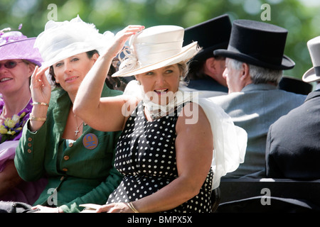 Rennen-Gänger kommen per Pferdekutsche, The Royal Ascot Race Meeting hängend auf ihre Hüte Stockfoto