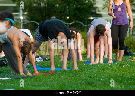 Yoga-Praktizierende Teilnahme eine kostenlose Yogastunde im Lenape Park in New York gegeben Stockfoto