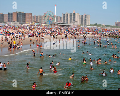 Eine Urlaub-Menge von mehr als 1 Million sonnt sich und schwimmt am Strand der berühmten Vergnügungspark Coney Island in Brooklyn, NYC Stockfoto