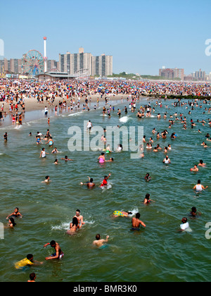 Eine Urlaub-Menge von mehr als 1 Million sonnt sich und schwimmt am Strand der berühmten Vergnügungspark Coney Island in Brooklyn, NYC Stockfoto