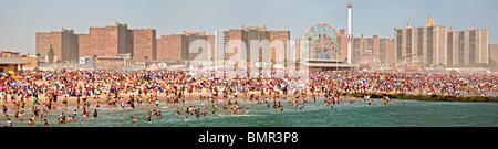 Eine Urlaub-Menge von mehr als 1 Million sonnt sich und schwimmt am Strand der berühmten Vergnügungspark Coney Island in Brooklyn, NYC Stockfoto