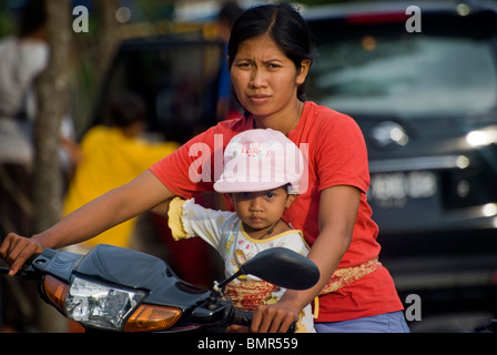 In Bali, Indonesien haben Motorräder übernommen als die wichtigste Form des Transportes.  Familien werden manchmal auf einem Fahrrad fahren. Stockfoto