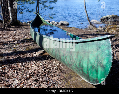 Grünes Kanu mit Wasser gefüllt, Finnland Stockfoto