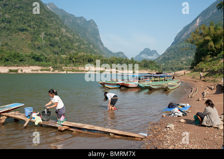 Laotische Frau wäscht Kleidung im Nam Ou Fluss Muang Ngoi Dorf im Norden von Laos Stockfoto