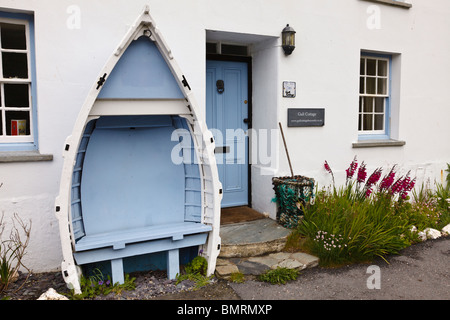 Sitz aus einem umgedrehten Jolle außerhalb Gull Cottage Bed und Breakfast, Boscastle, Cornwall, England hergestellt Stockfoto