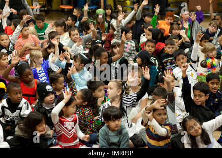 Grundschule 3. Klasse, die Schüler während einer Schulversammlung während Kinderbuchautorin Derrick Barnes liest darauf reagieren Stockfoto