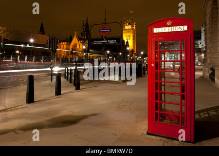 Britische Telefonzelle außerhalb Westminster u-Bahnstation in Whitehall, London in der Nacht. Stockfoto