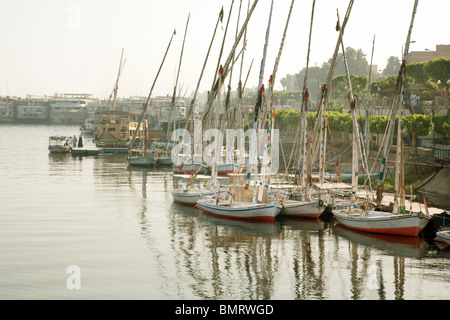 Feluccas und Kreuzfahrtschiffe gebunden an den Ufern des Flusses Nil bei Luxor, Ägypten, Afrika Stockfoto