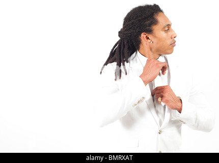 Porträt eines kubanischen Mannes mit Dreadlocks, in weißem Anzug, auf weißem Hintergrund. Stockfoto