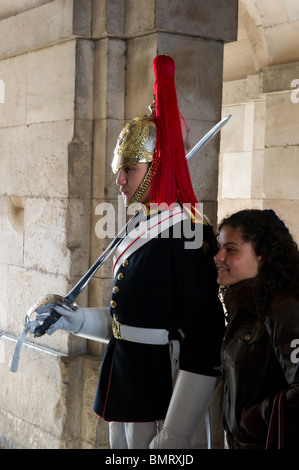 Ein Tourist hat ihr Foto neben einem Mitglied der Household Cavalry auf Horse Guards Parade, London. Stockfoto