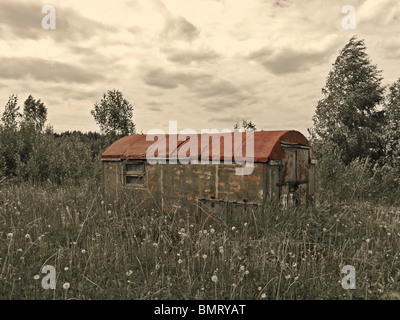 Alten Wohn-Haus aus Eisenbahnwaggon im Ödland in Izhevsk Region, Udmurtische Republik, Russland - in Sepia und roten Farben Stockfoto