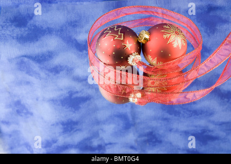 zwei Weihnachtskugeln mit blauem Hintergrund, große rote Schleife, Reflexionen und Exemplar Stockfoto