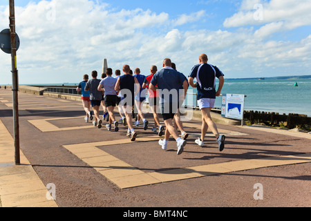 Gruppe von Matrosen laufen "im Schritt" auf Southsea Promenade, unter der Leitung von ein Physical Training Instructor, Hampshire, UK Stockfoto